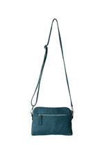 Load image into Gallery viewer, Back view of a teal leather crossbody bag. With fully adjustable strap and silver zips, Hoopla brand.
