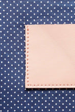 Load image into Gallery viewer, Navy with white polka dot cotton lining on a cream leather clutch 