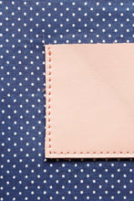 Load image into Gallery viewer, Navy with white polka dot cotton lining on a cream leather clutch
