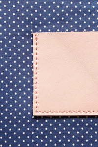 Navy with white polka dot cotton lining on a cream leather clutch 