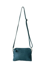 Load image into Gallery viewer, Front view of a teal leather crossbody bag. With fully adjustable strap and silver zips, Hoopla brand. 