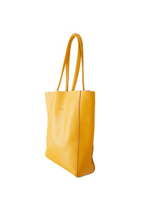 Side view of Hoopla leather mustard portrait tote with long padded handles.