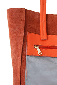 Inside zipped pocket of Hoopla leather orange tote. 